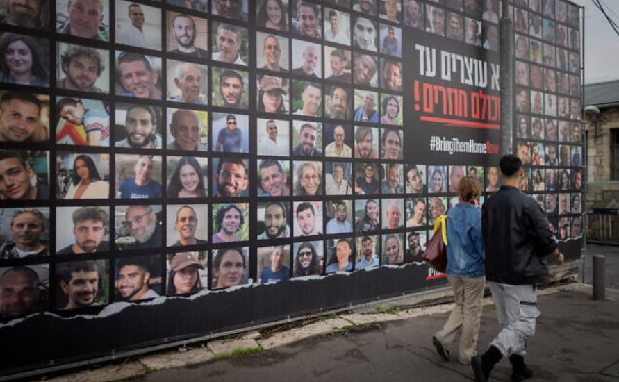 Луѓето поминуваат покрај сликите на заложниците што ги држи Хамас во Газа, во Ерусалим